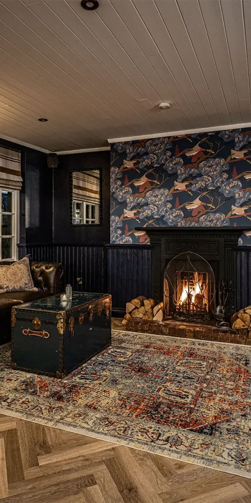 Armchairs beside the open fire at The Bradgate
